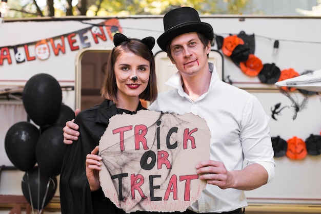 Smiley couple holding halloween sign