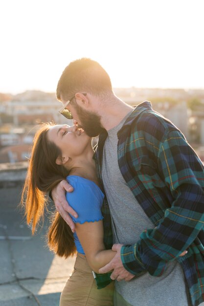 スマイリーカップルが屋外でお互いにキス