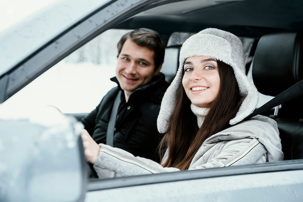 Smiley couple posing together in the car while on a road trip