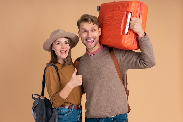Smiley couple ready for traveling with luggage