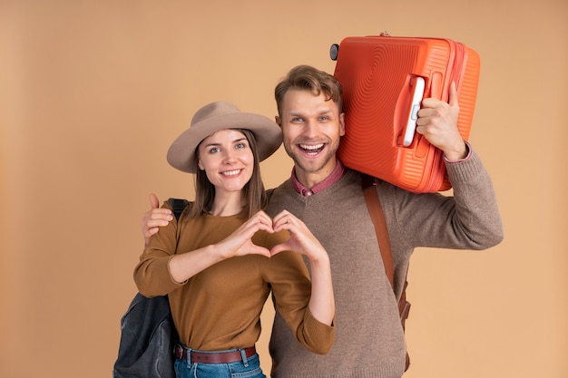 Smiley couple ready for traveling with luggage