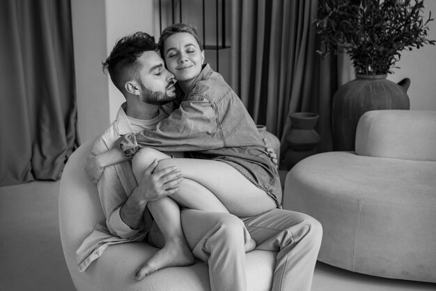 Smiley couple sitting on chair black and white authenticity