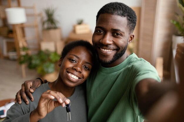 Smiley couple taking selfie in their new home