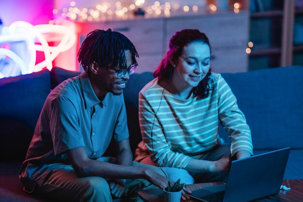 Smiley couple using laptop at home