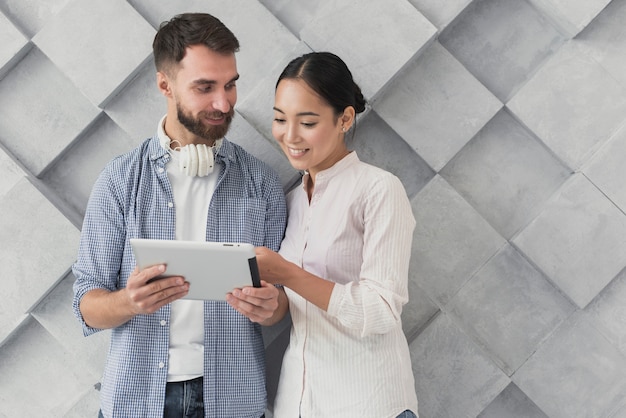 Smiley coworkers looking at tablet