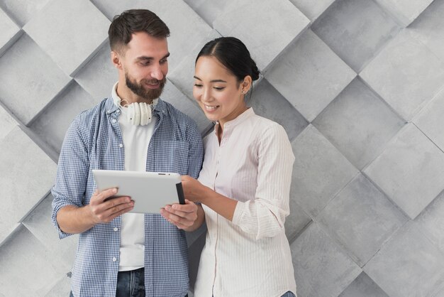 Smiley coworkers looking at tablet