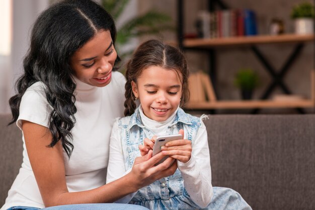 Smiley daughter using mom phone