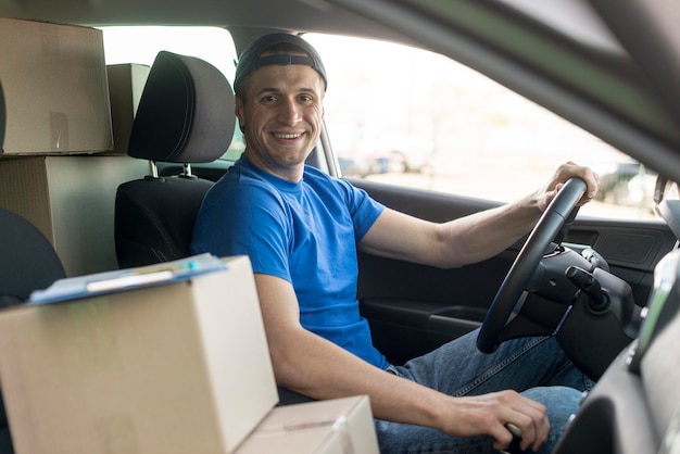 Free photo smiley delivery guy driving