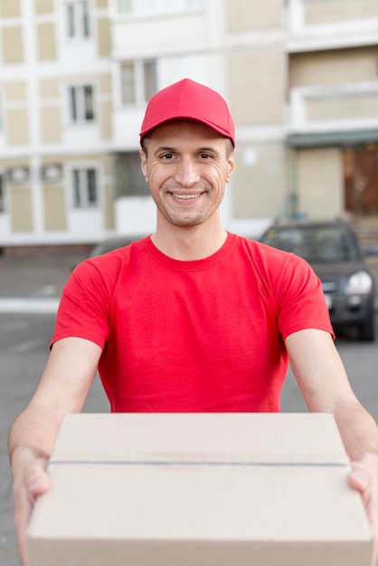 Smiley delivery guy holding box