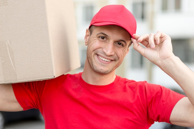 Free photo smiley delivery man doing his job