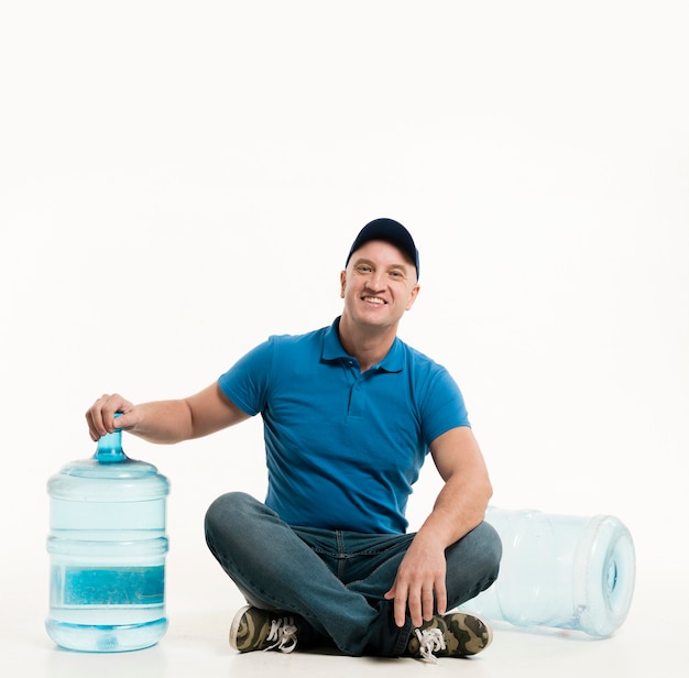 Smiley delivery man posing while sitting down