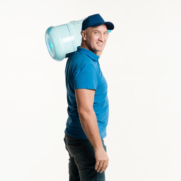 Smiley delivery man posing with water bottle