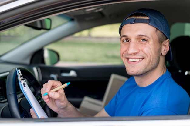 Free photo smiley delivery man signing paper