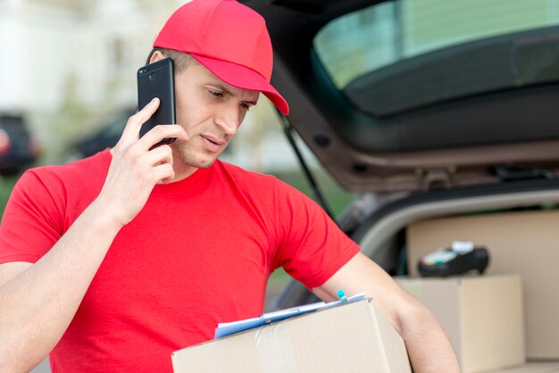 Smiley delivery man with phone