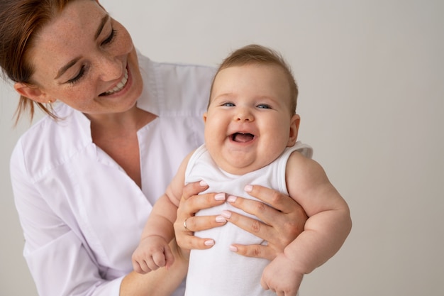 Medico sorridente che tiene vista frontale del bambino