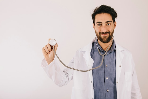 Foto gratuita medico di sorriso in posa con lo stetoscopio