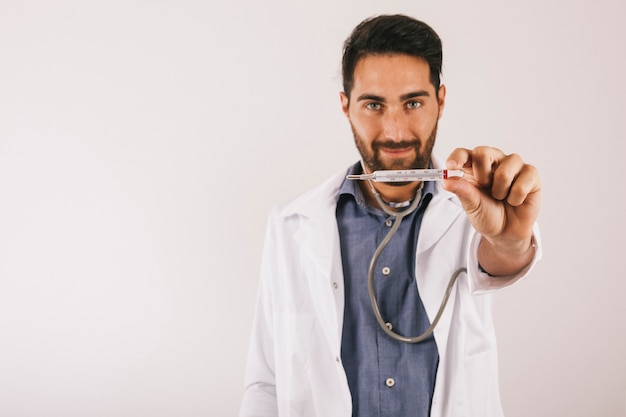 Free photo smiley doctor posing with thermometer