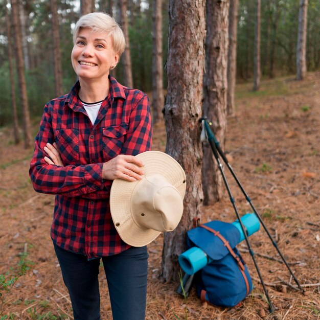 Smiley elder tourist woman in the forest
