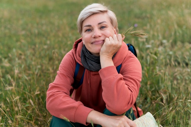 Smiley elder tourist woman outdoors in nature