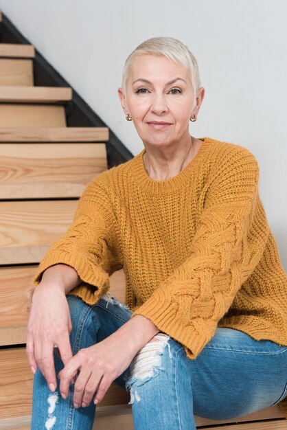 Smiley elder woman posing on stairs