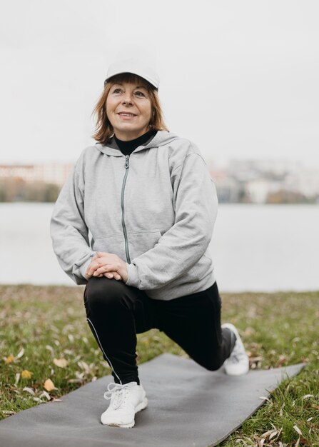 Smiley elderly woman working out outdoors