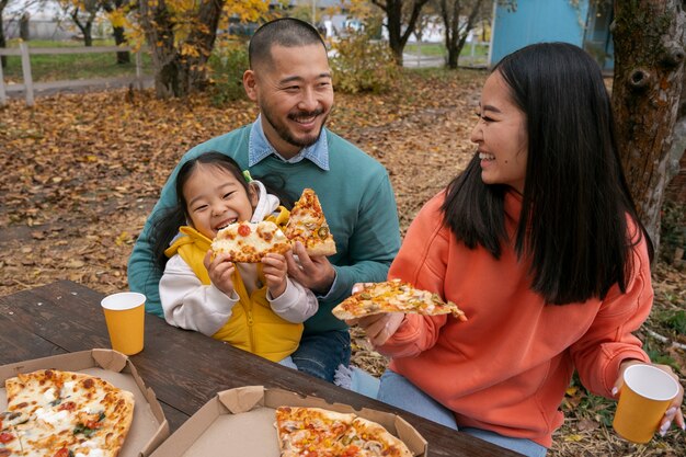 Smiley family with delicious pizza medium shot