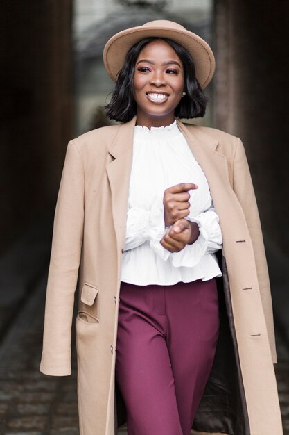 smiley fashionable woman model posing outside