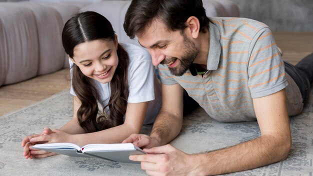 Smiley father and daughter reading