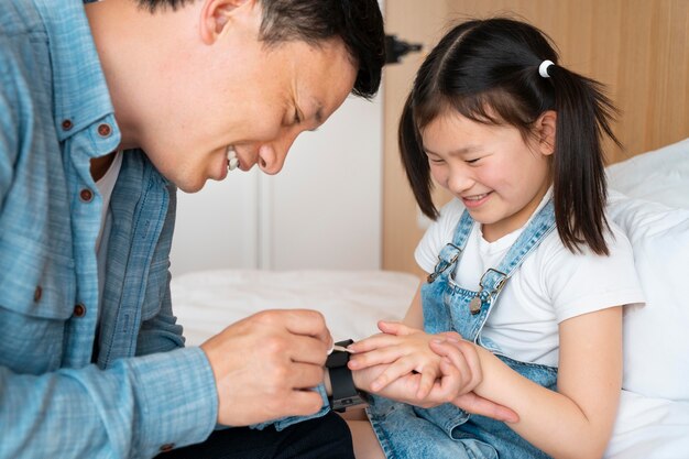 Smiley father painting girl's nails