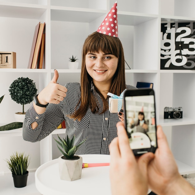 Free photo smiley female blogger streaming birthday with smartphone