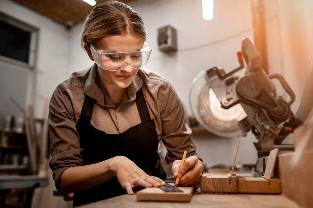 Smiley female carpenter working in the studio