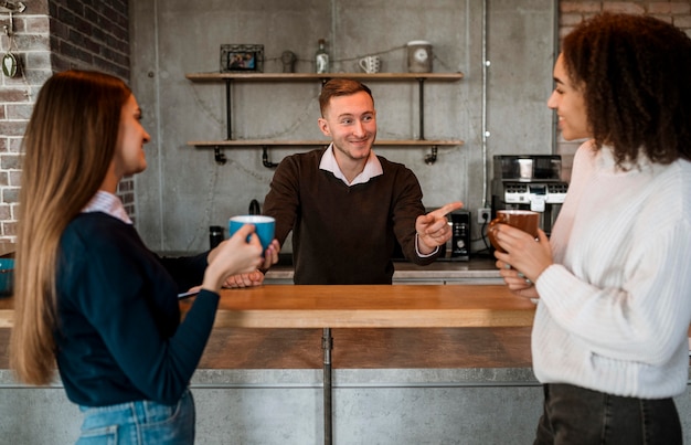 会議中にコーヒーを飲んでいるスマイリー女性の同僚