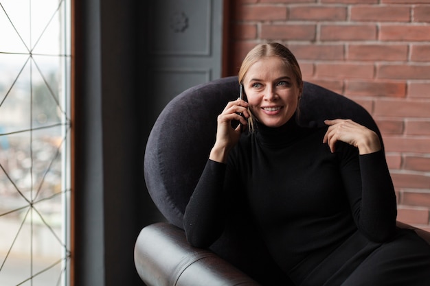 Free photo smiley female on couch talking over phone