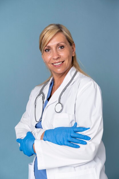 Смайлик женщина-врач позирует в костюме и стетоскопе