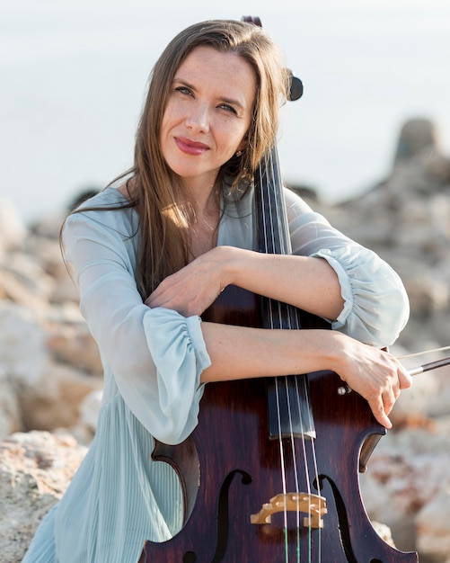 Foto gratuita musicista femminile di smiley con il violoncello