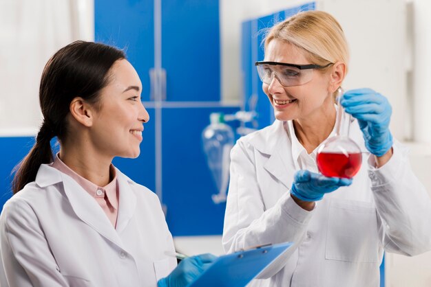 Smiley female scientists holding substance in the lab