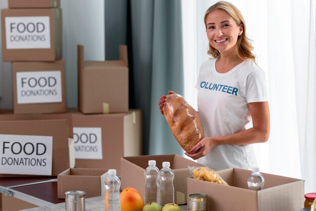 Смайлик женщина-волонтер помогает с пожертвованиями на еду