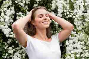 Foto gratuita faccina femmina con fiori dietro