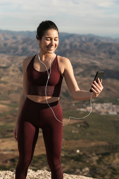 Smiley female with headphones looking at mobile