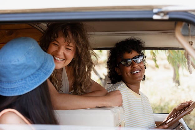 Free photo smiley friends in campervan side view