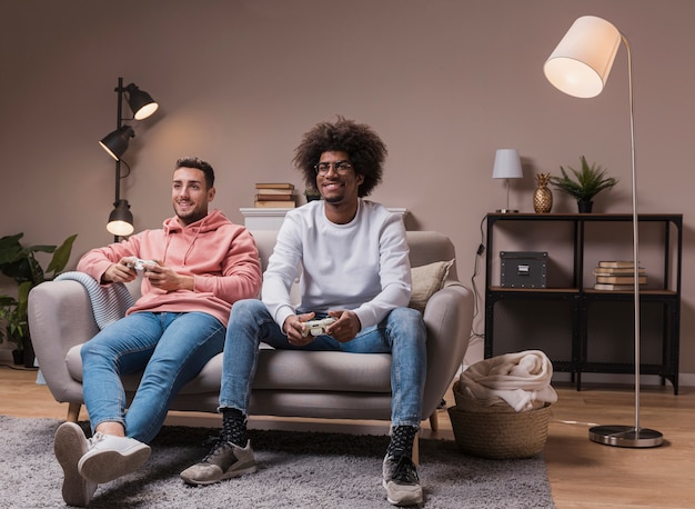 Free photo smiley friends on couch playing games