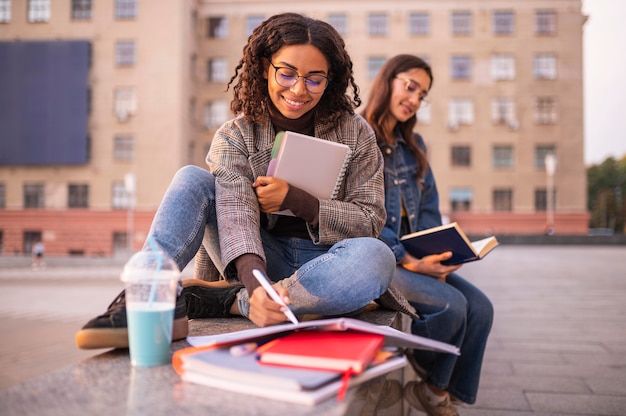 Smiley friends doing homework outdoors