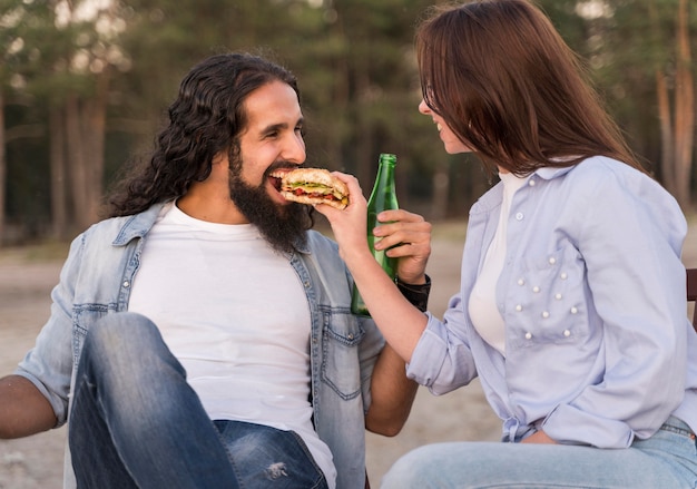 Amici di smiley che mangiano e bevono birra all'aperto