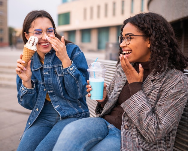 Друзья-смайлы веселятся вместе на свежем воздухе с мороженым и молочным коктейлем