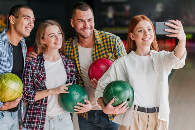 Foto gratuita amici di smiley che propongono in un randello di bowling