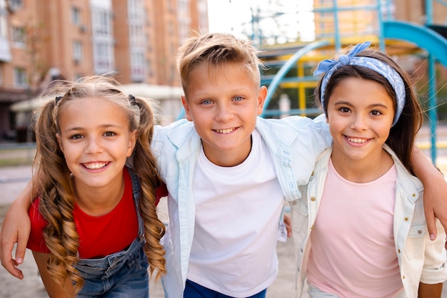 Foto gratuita amici di smiley in posa per la fotocamera nel parco giochi