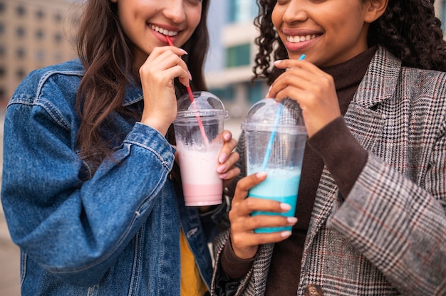 Smiley friends together outdoors with milkshakes