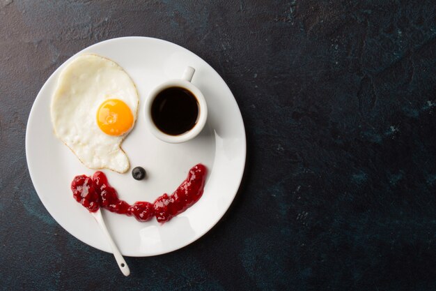 Smiley from fried egg and coffee cup