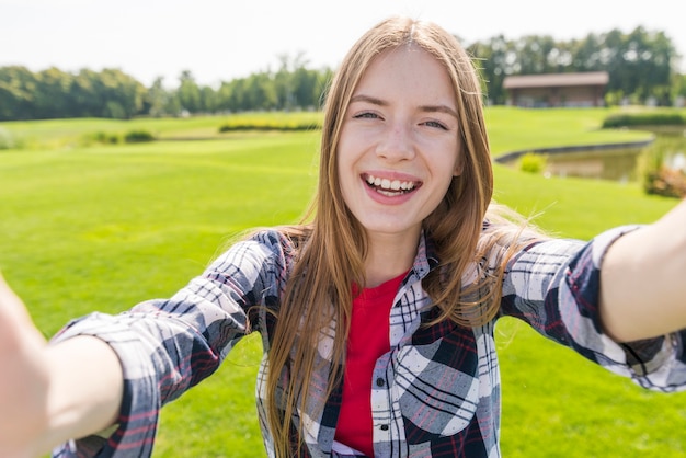 Foto gratuita ragazza sorridente che tiene la macchina fotografica