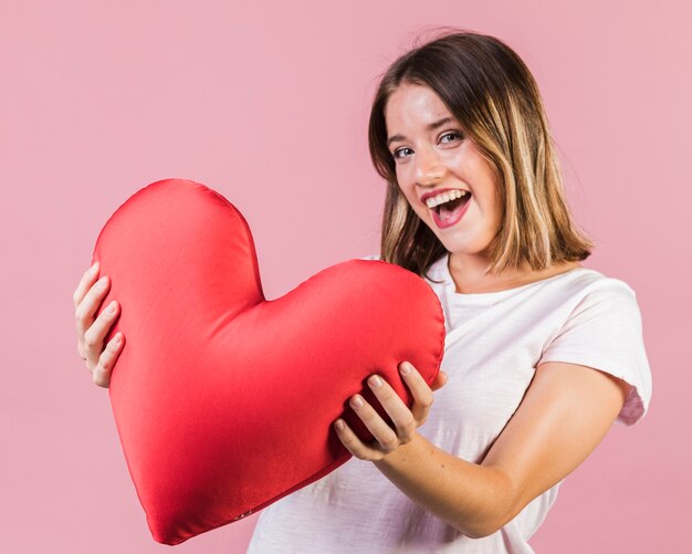 Smiley girl holding a heart shaped pillow